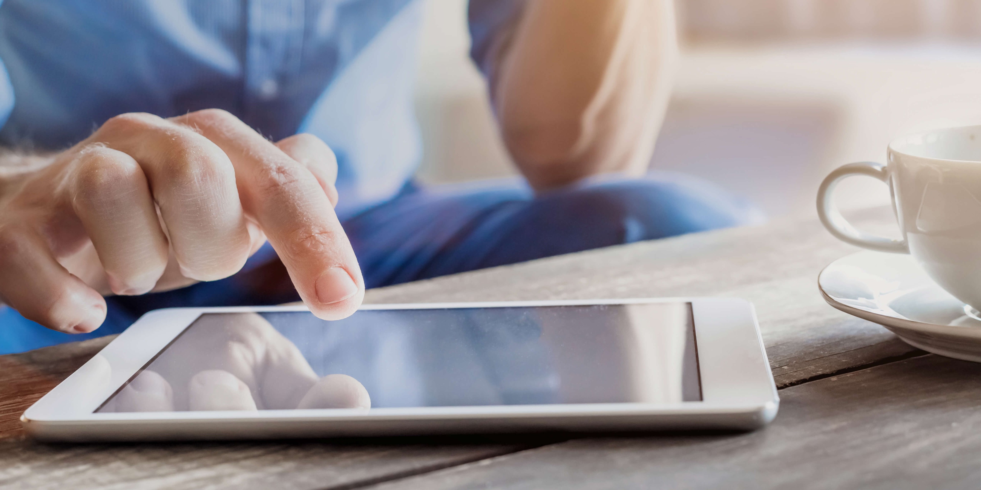 Tablet wird von Mann in blauem Hemd bedient