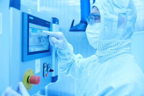 A person in protective clothing operates a monitor