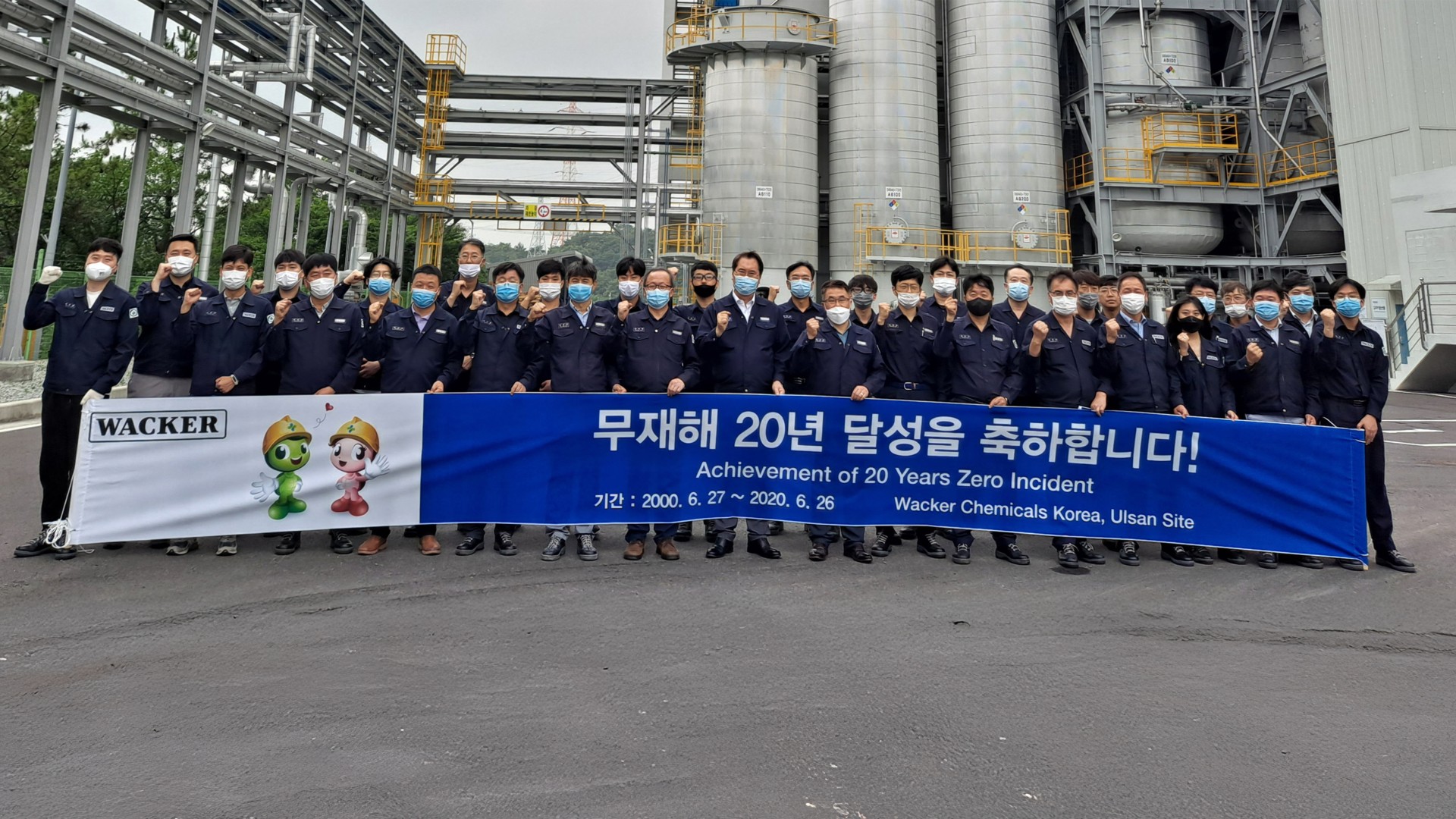 Employees hold up a banner and celebrate 20 years of accident-free work