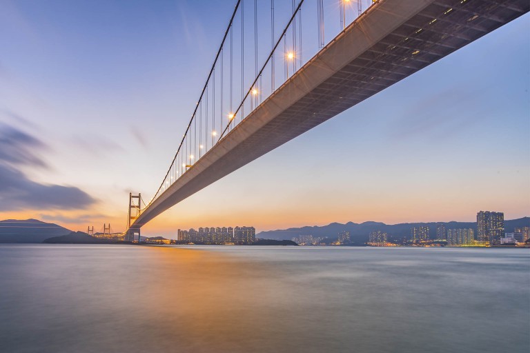 Br&uuml;cke vor Stadt im Sonnenuntergang