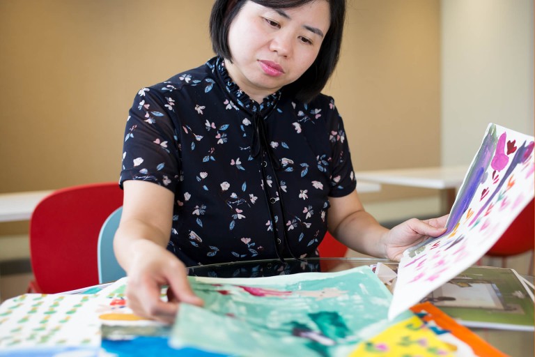 Cindy Xie mit gemalten Kinderbildern
