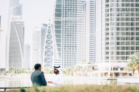 Two Arab businessmen in front of the Dubai skyline