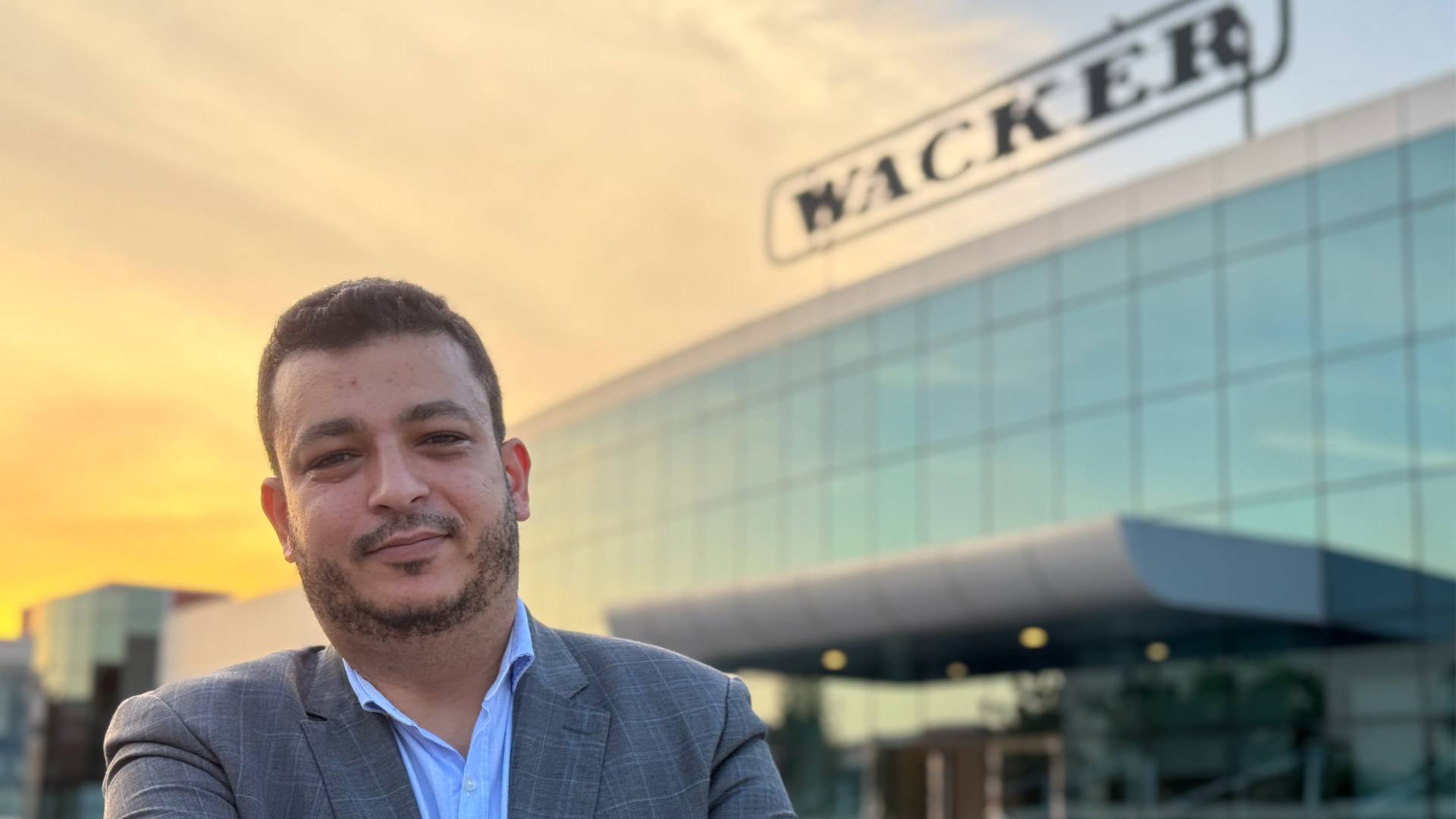 An employee of WACKER Middle East in front of the company building