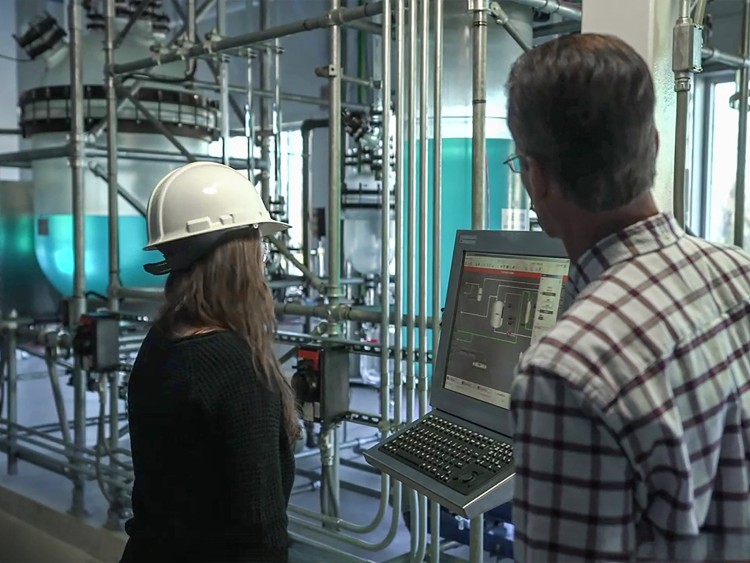 Ein Mann und eine Frau schauen in einer Produktionsumgebung auf einen Analyse-Bildschirm
