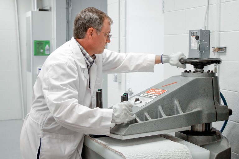 Forscher im wei&szlig;en Kittel im Labor an einem Ger&auml;t