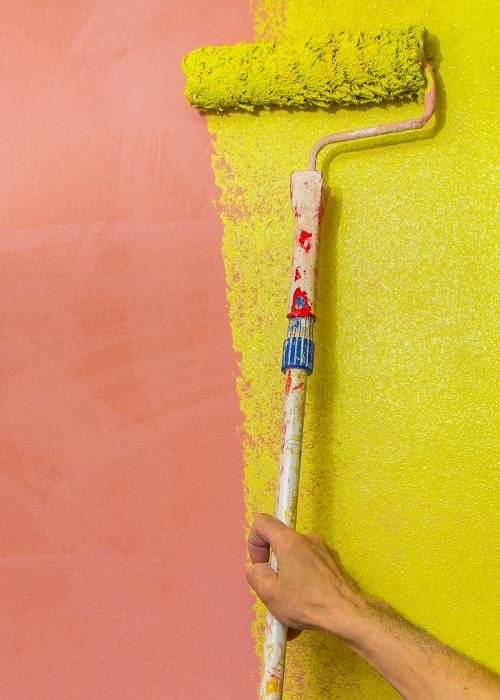 Colored wall is painted with a paint roller
