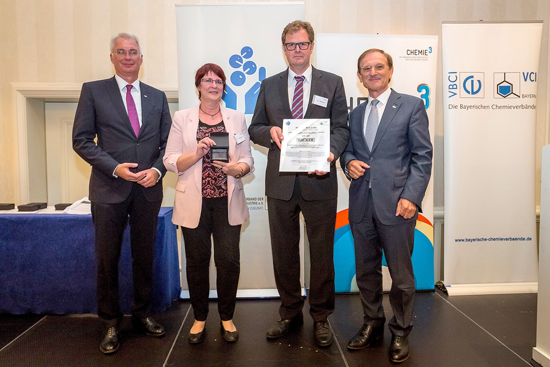 Walter Vogg (left, director general of the VCI&rsquo;s Bavarian branch) and Dr. Guenter von Au (right, chairman of the VCI&rsquo;s Bavarian branch) congratulated Dr. Jutta Matreux (head of Corporate Sustainability at WACKER) and Dr. Mathias Bremer (WACKER POLYSILICON)