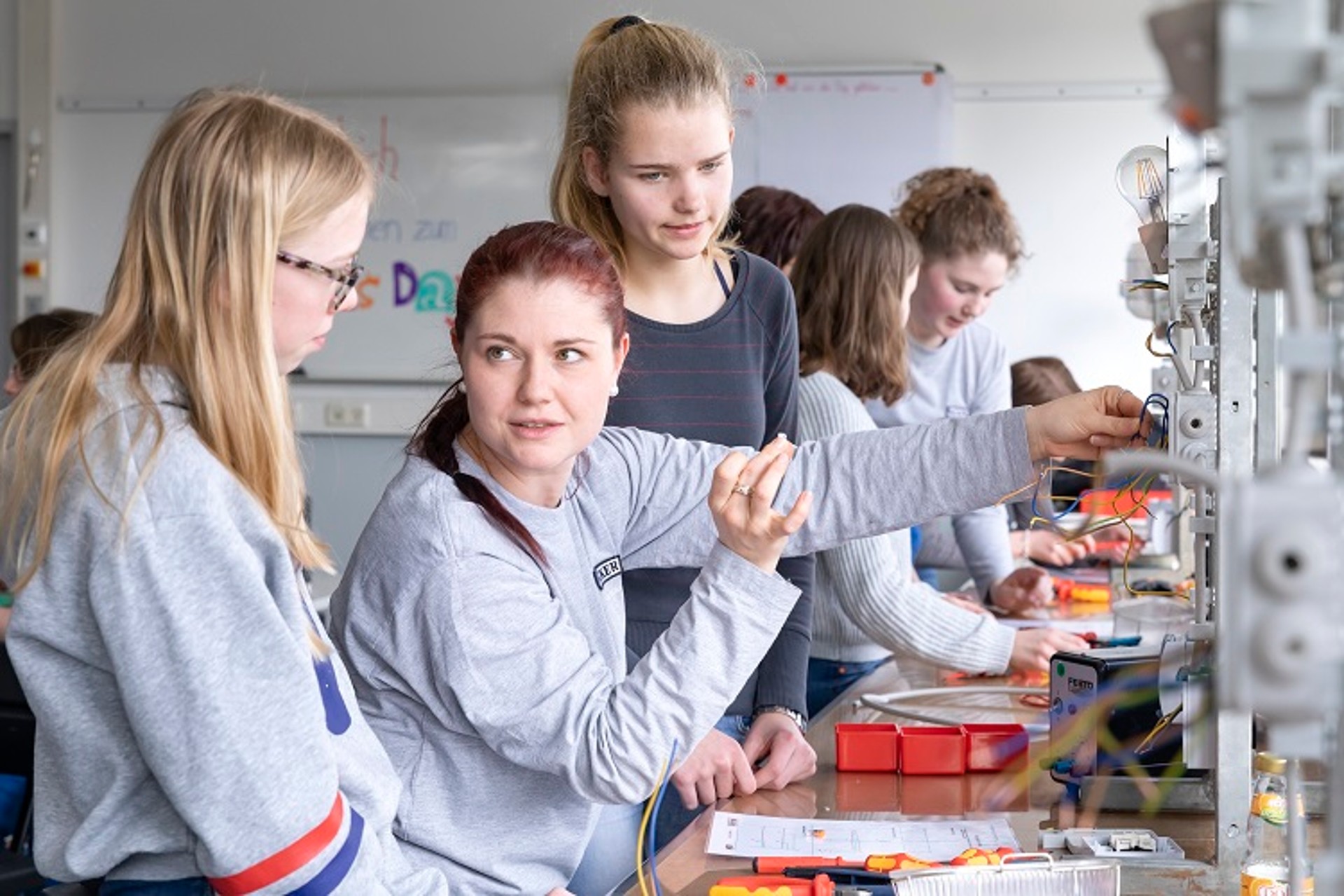 Eine Lichtschaltung sieht zun&auml;chst kompliziert aus. Jessica Ebner, Auszubildende zur Elektronikerin f&uuml;r Automatisierungstechnik bei WACKER, erkl&auml;rt den Girls&lsquo; Day Teilnehmerinnen wie es funktioniert. 