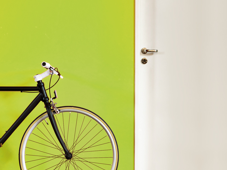 Black bike infront of orange painted wall.